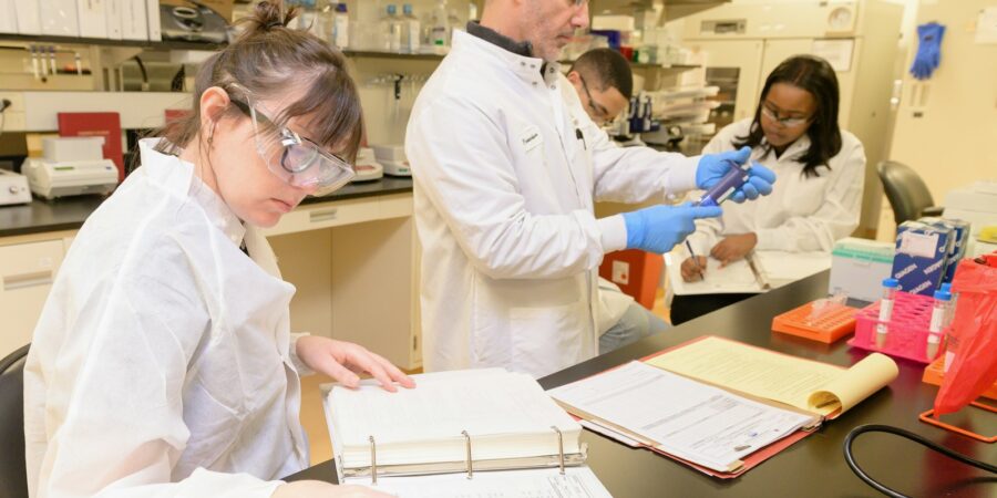Исследователи работают в лаборатории над RNA-вакцинной технологией